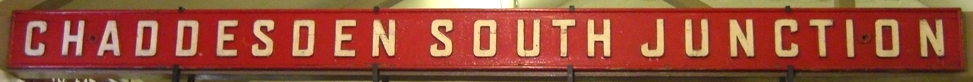 A bright red Midland Railway signal box name board reading Chaddesden South Junction