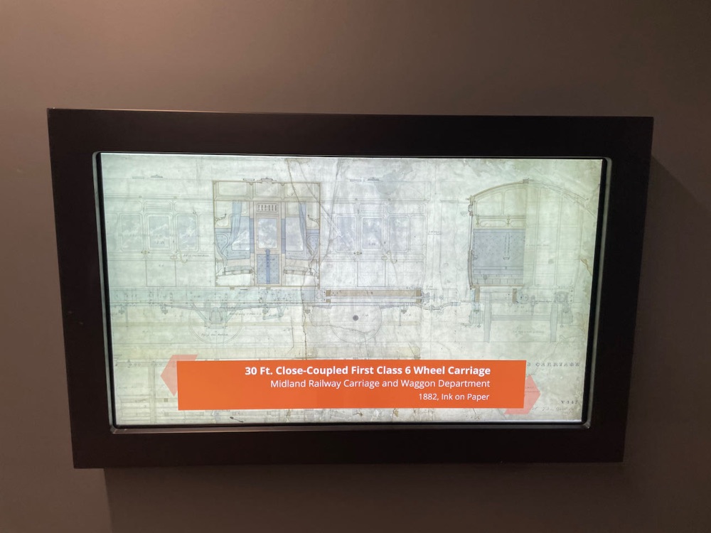 A display screen with a digital copy of a Midland Railway carriage drawing and the caption 30ft close coupled first class six wheel carriage
