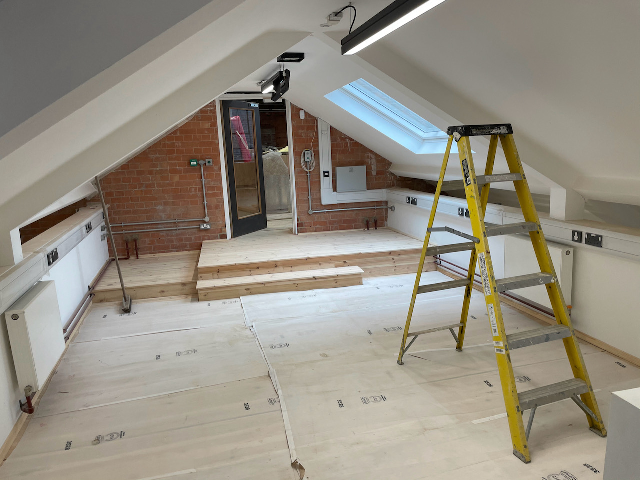 A room with a pitched ceiling and a skylight