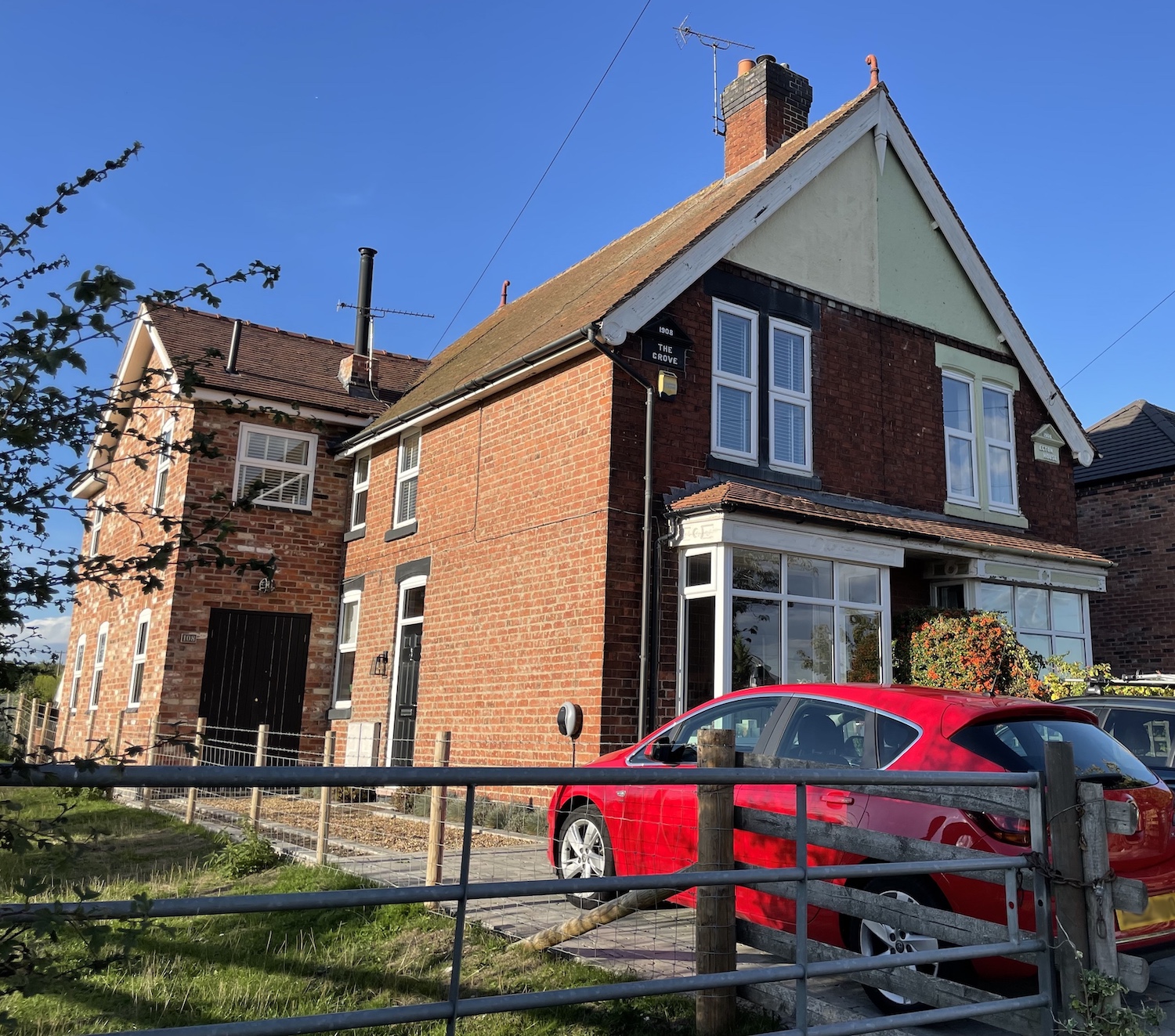 Semi detached house with a name tile in the eaves reading The Grove 1908