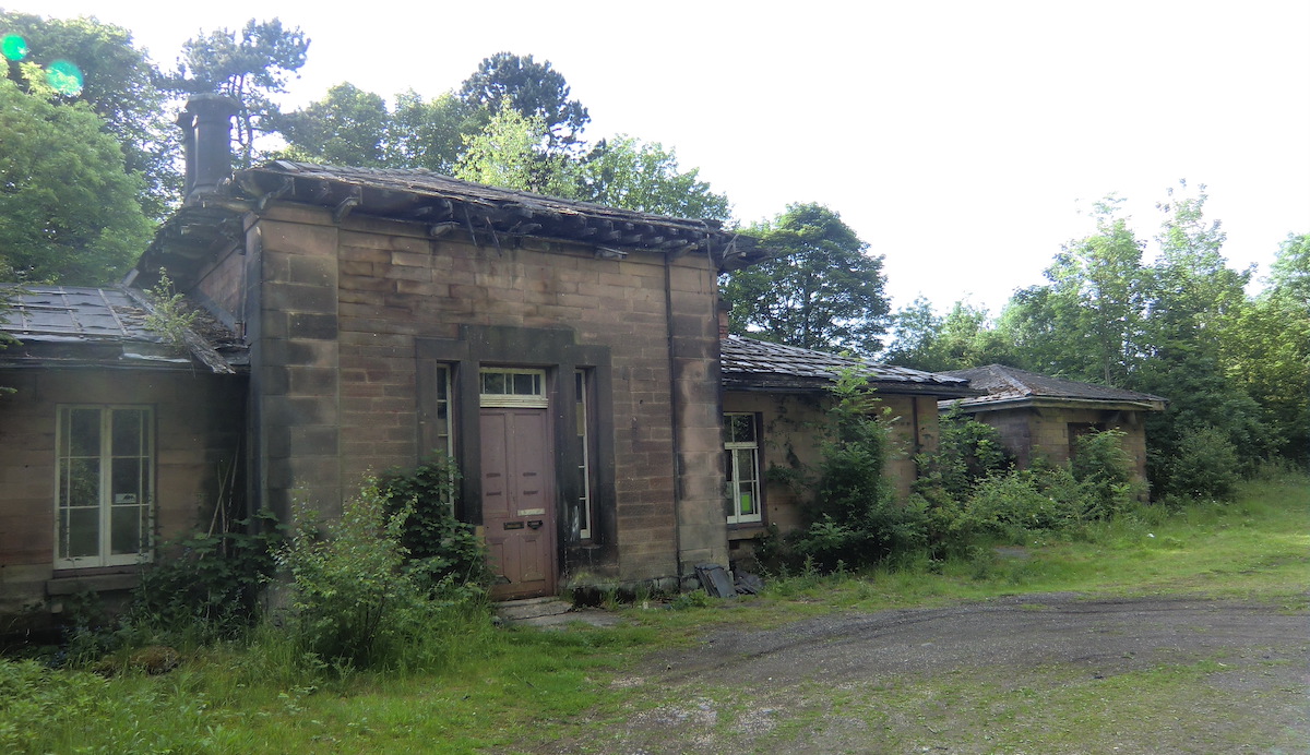 Image shows the derelect Wingfield railway station in Derbyshire surrounded by overgrowth and decay.