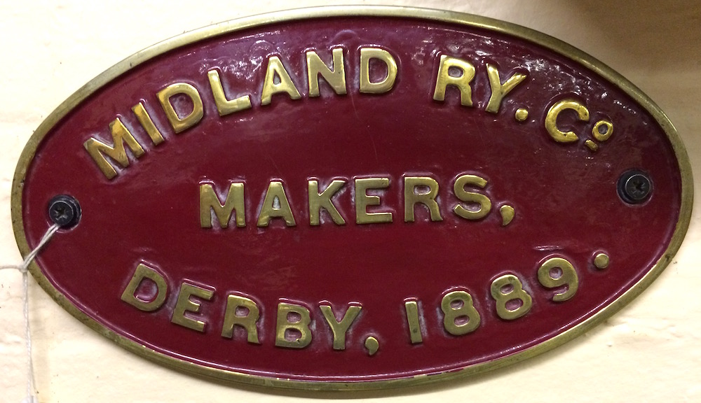 An oval cast brass plaque with maroon background which reads 'Midland Ry Co. -  Makers  -  Derby, 1889.'