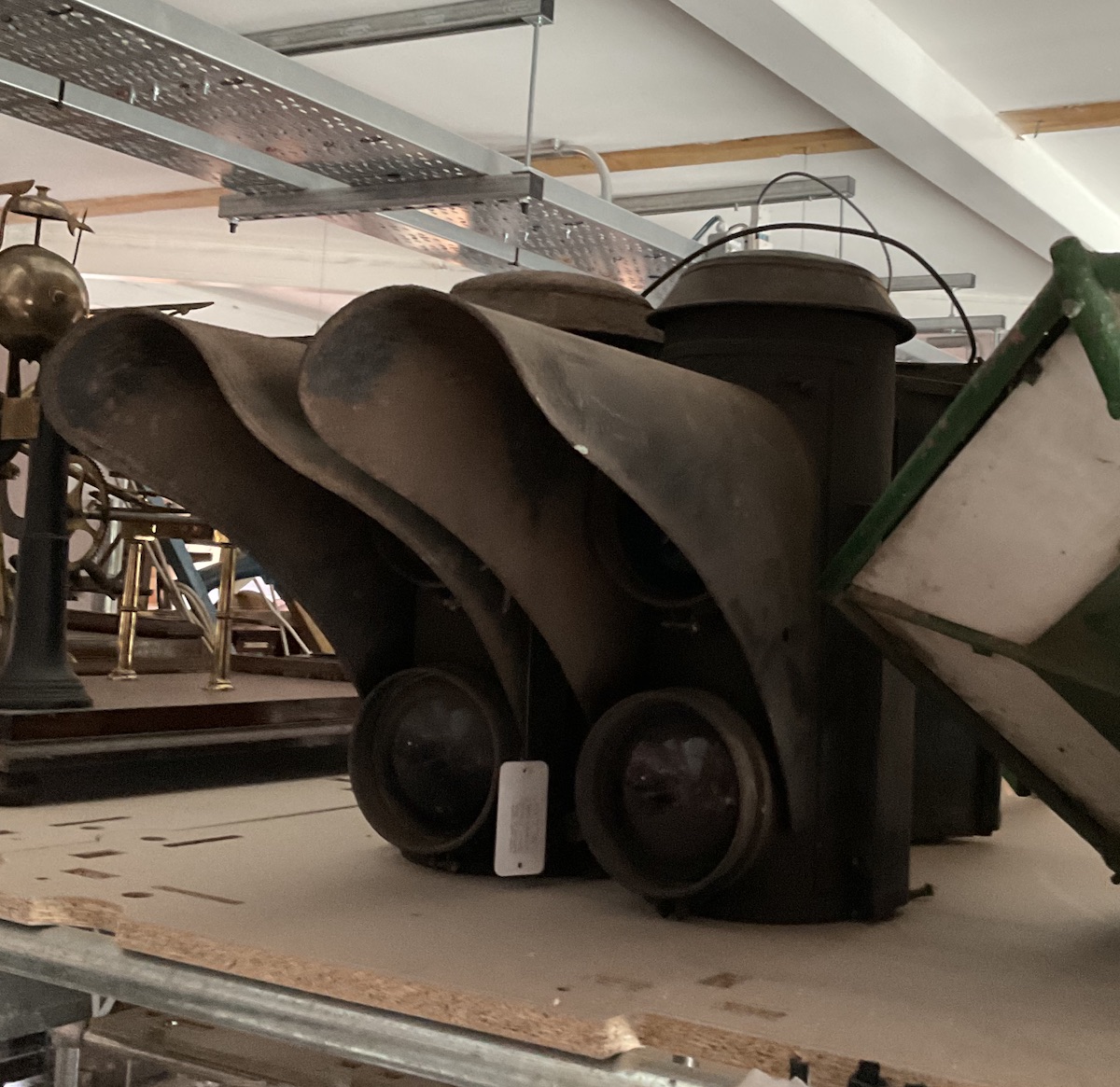 A pair of electric signal lamps with a large light hood protruding from the front of each one, each with two coloured lights