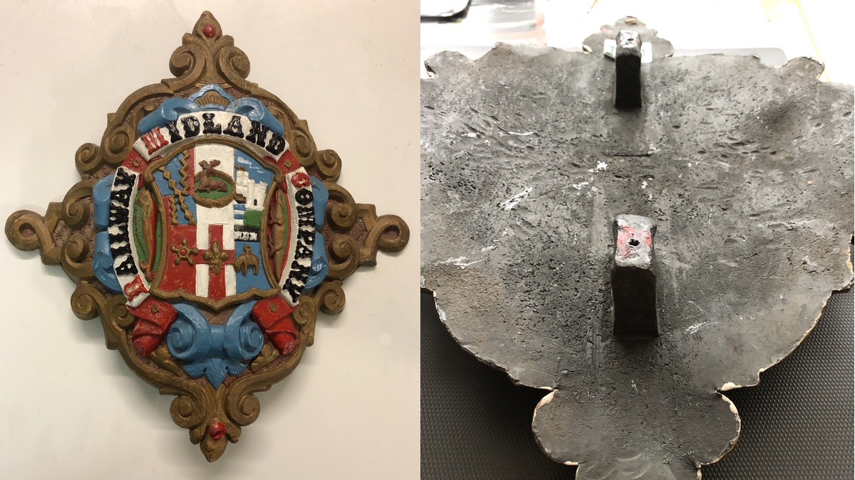 Another viewe of the crest alongside a view of its rear showin gthe mounting lugs 