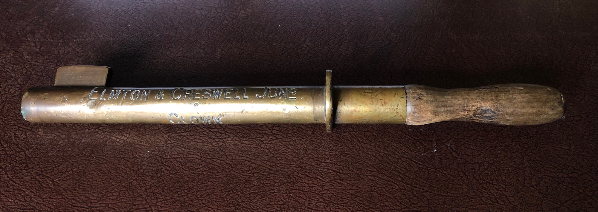A long staff, looking a bit like the baton a relay racer might hand over or even a policeman's truncheon. Largely made of brass but with a wodden handle, it is inscribed as below.