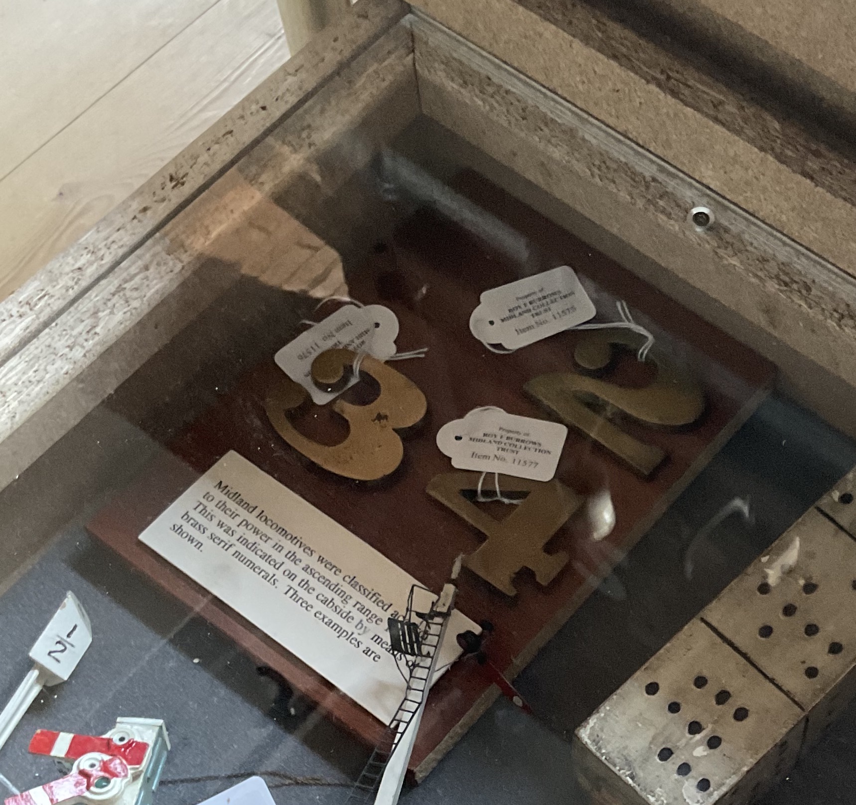 Looking in the drawer we see various itmes including small brass numbers 2, 3 and 4