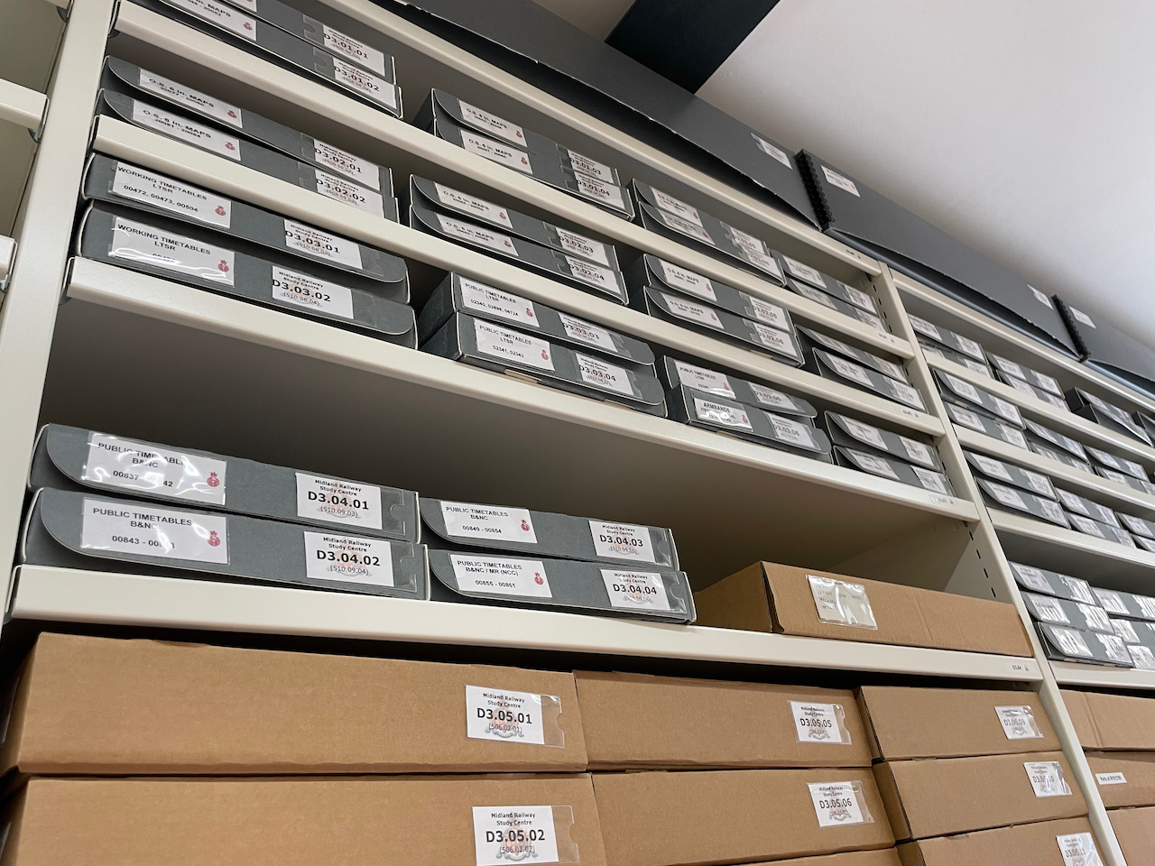 A row of steel racking filled with document storage boxes