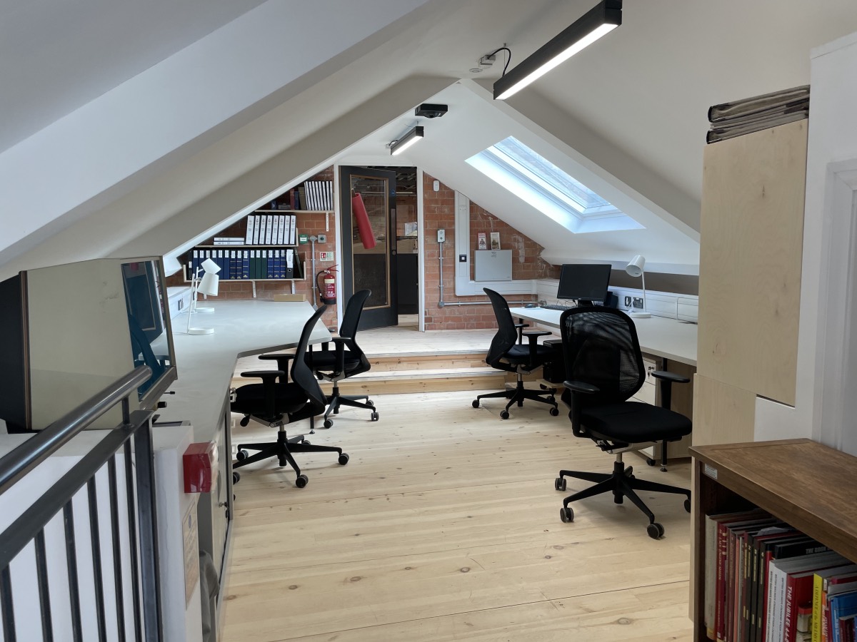 A room built into the eaves of the roof with desks either side and a central circulation space